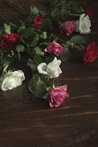 木桌上留下的红色粉色和白色玫瑰图片