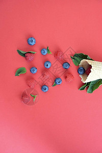 以丰富多彩背景的蓝莓草莓和薄荷为标志的冰淇淋甜筒图片