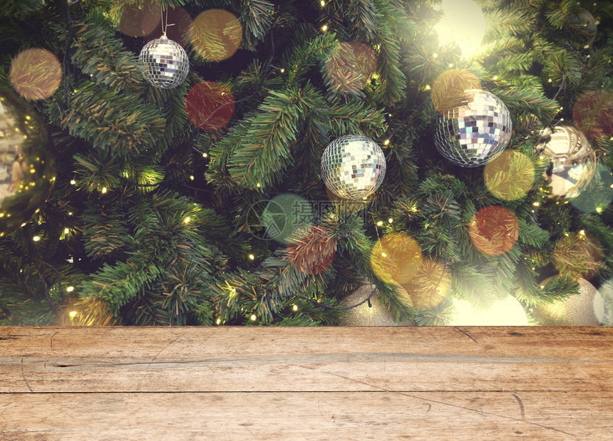 在圣诞节或新年快乐时间背景前的空旧木桌圣诞树与五颜六色的球假日背景产图片