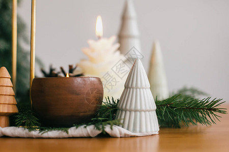 圣诞树蜡烛和松果在木桌上的仿古织物上图片
