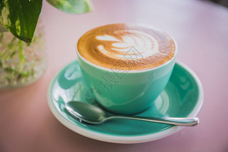 咖啡与美丽的拿铁艺术在绿色杯子和茶托在咖图片