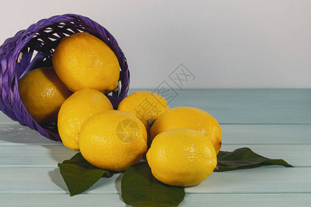 蓝木制桌上的柠檬和篮子图片