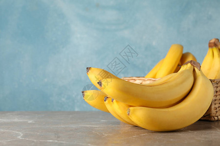 蓝色背景下的篮子和香蕉新鲜水果图片