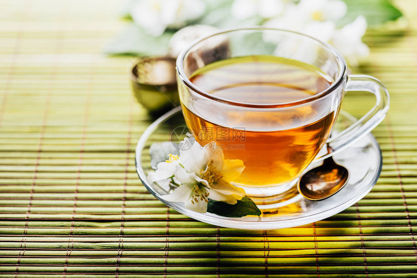 一杯热凉茶竹背景特写木桌上有机绿茶和新鲜茉莉花的茶杯健康的替代药物和图片