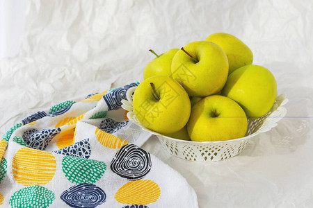 白纸背景的盘子上的黄苹果与苹果金苹图片