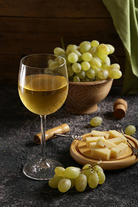 白葡萄酒和绿葡萄的玻璃杯图片