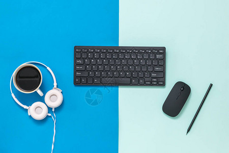两色背景的咖啡耳机键盘和鼠标计算机图片