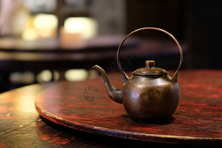 木制桌上一个旧铜茶壶传统中华茶壶图片