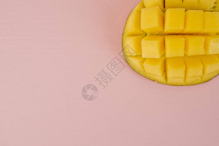 平铺在粉红色背景桌上的芒果图片