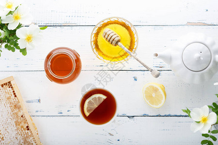 蜂蜜背景玻璃罐中的甜蜂蜜蜂蜜梳子和桌上的新图片