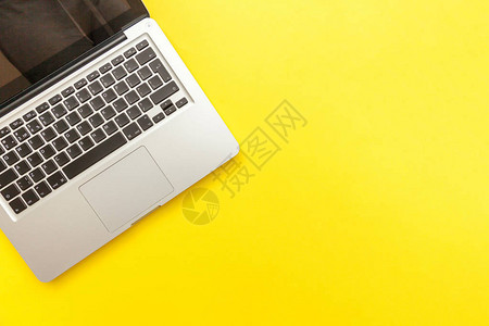 以黄色案头背景孤立的键盘膝上型计算机图片