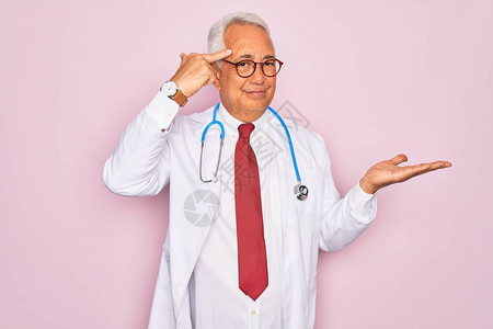 中年老灰发医生男子身着听诊器和专业医疗大衣图片