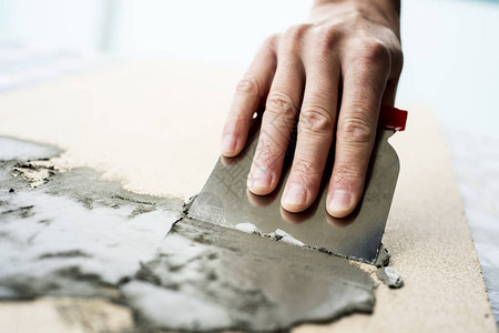 在纤维板表面撒布水泥混凝土并用刮碎机擦到一图片