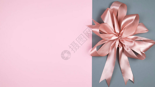 彩色背景上的粉红色缎面蝴蝶结装饰背景顶视图文本空图片