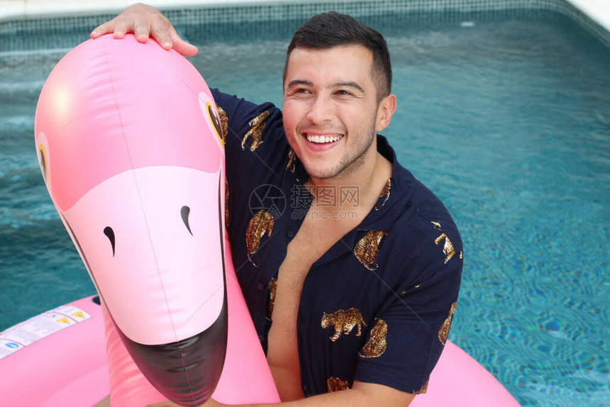 英俊年轻男子的近视肖像在游泳池里用粉红图片
