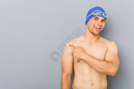 年轻的职业游泳运动员笑着站在一边图片