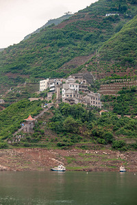 长江西陵峡谷绿色斜坡上的村庄建筑图片