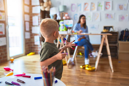 年轻的白种人孩子和老师在幼儿园玩耍图片