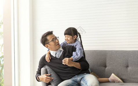 亚洲父亲和女儿在家里的客厅一起玩耍图片