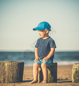 蹒跚学步的男孩走在阳光明媚的海滩上走在沙子的小孩美丽的励志海滩图片
