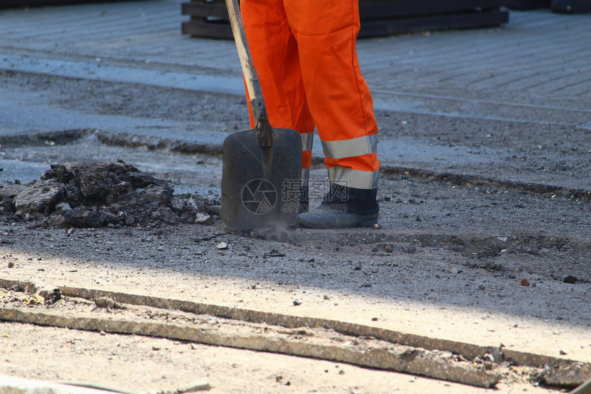 工人拆除旧路面铺设新沥青道路维修