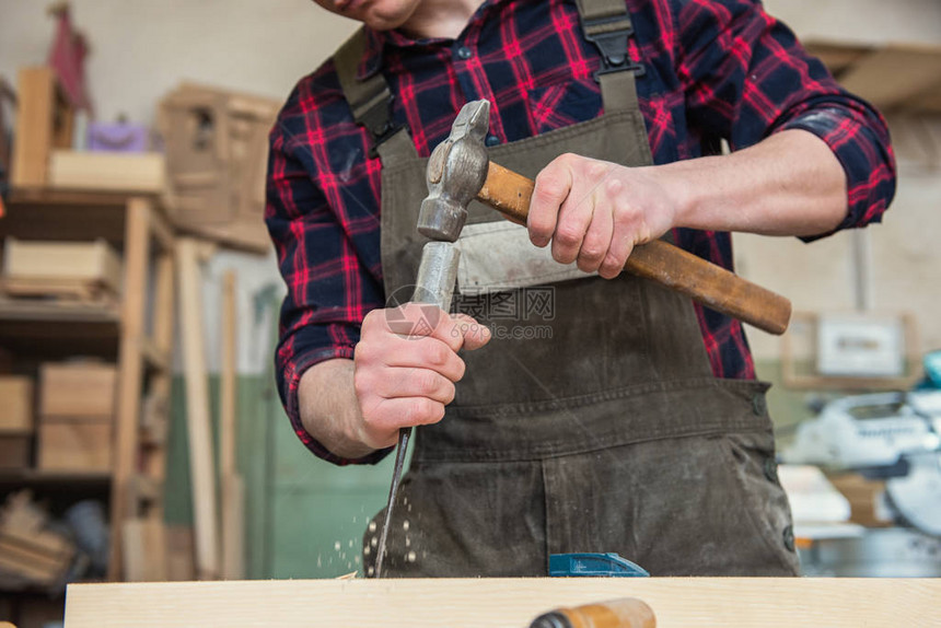 木匠在木制车间里用凿子和锤子工作专业木工和手图片