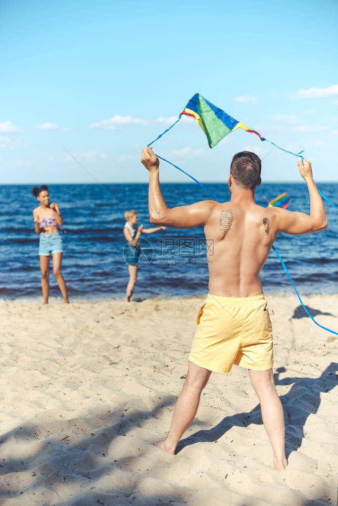 花时间一起在沙滩上玩风筝的多文化朋友有选择图片