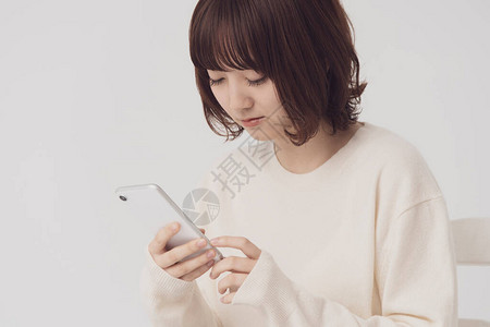 亚洲日语年轻女经营智能手机图片