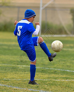 运动健壮的年轻男孩在足球比赛中表演图片
