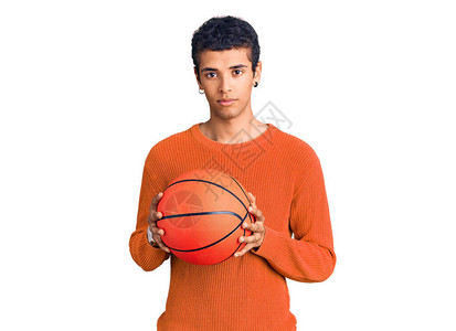 年轻的非洲裔美国人抱着篮球的思维态度和冷静的表情图片
