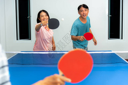 情侣们在室内玩乒乓球或乒乓球图片