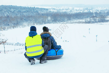 冬季有趣的活动在雪管上骑下山推背景图片