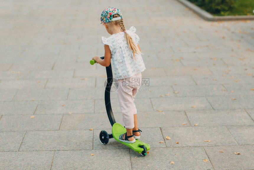 在城市街道上骑摩托车的小女孩图片
