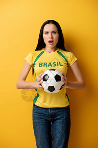 震惊的女足球迷拿着黄色球图片