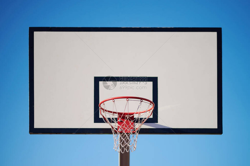 有圆环的白色篮球板在蓝天背景图片