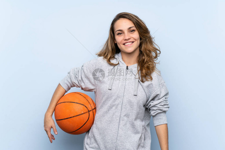 年轻的金发女子与篮球图片