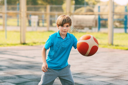 专注的可爱男孩运动员在篮球比赛中带领球一个男孩放学后打篮球运动健康生图片