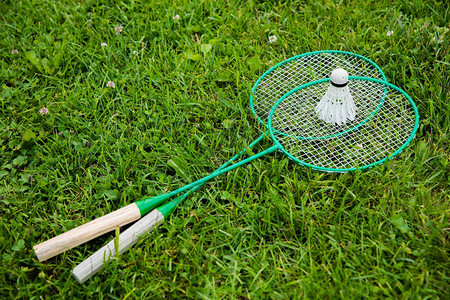 羽毛球拍和羽毛球躺在绿草上图片