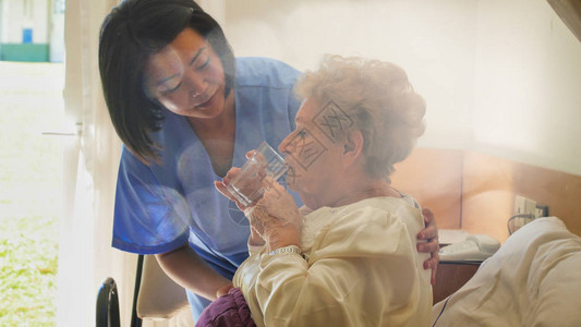 年轻的亚洲女医生帮助老年退休妇女在病图片