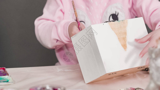 小女孩在木箱上画着白独角图片
