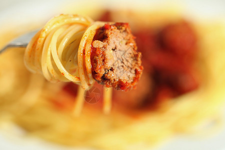 肉丸番茄酱和面条在叉子上背景图片
