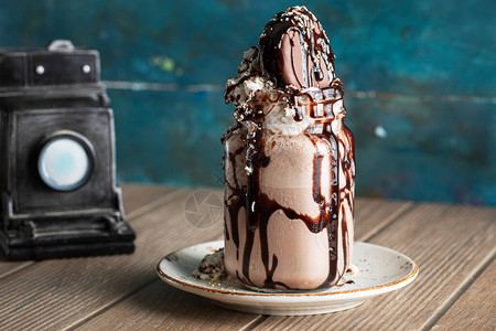 白碟里加苦巧克力酱的冰淇淋甜点图片