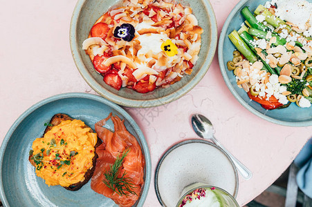时尚咖啡厅的健康早餐包括炒鸡蛋配熏鲑鱼烤蔬菜配荷包蛋草莓煎饼配酸奶图片