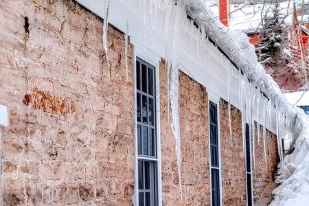 尖锐的冰柱对着家窗和外墙石块图片