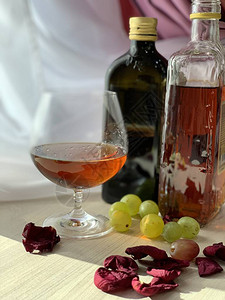 瓶装饮料一杯威士忌绿葡萄玫瑰花瓣图片