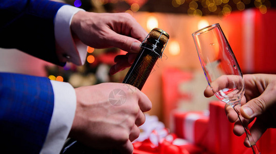 喝香槟或起泡酒用香槟庆祝新年手打开香槟瓶背景图片