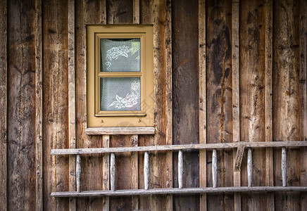 梯子位于一栋房屋或木柴谷仓小窗图片