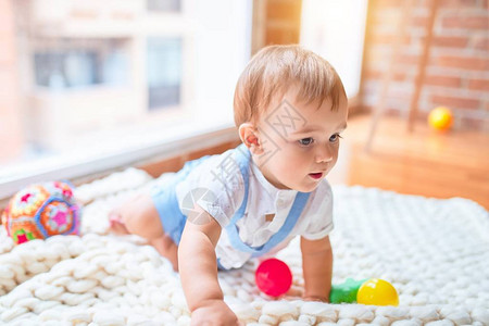 坐在毛毯上坐着的可爱的小孩儿在幼儿园背景图片