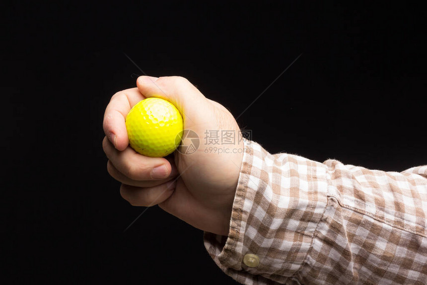 黑人背景的黄色高尔夫球在成年人手里YelyGlo图片