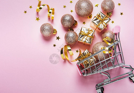 带球的圣诞购物车金色假日装饰品粉色面条背景平坦躺下图片